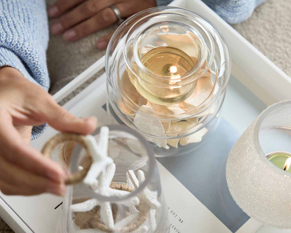 Illusion Tealight Holder with a lit tealights and decorative items around ti.